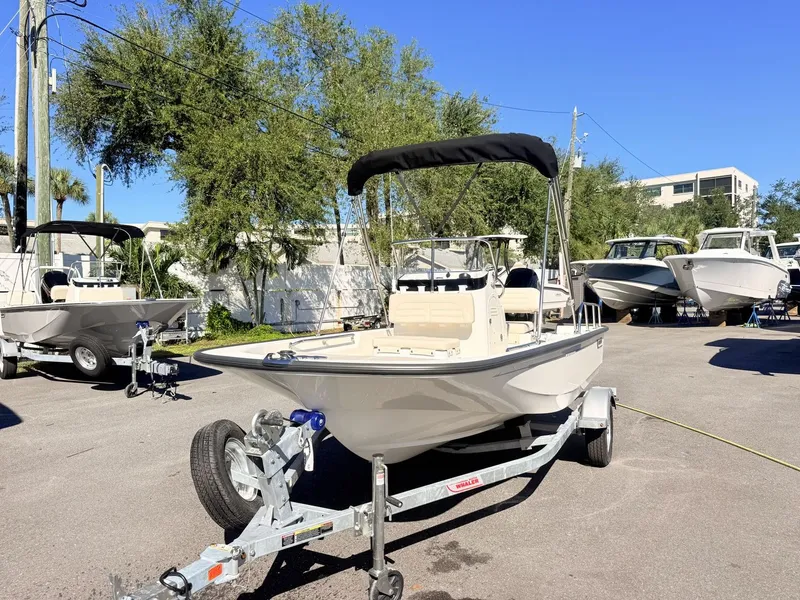 Slide: The Image of A 2027 Boston Whaler 150 Montauk on a trailer in a sunny outdoor setting. - 9