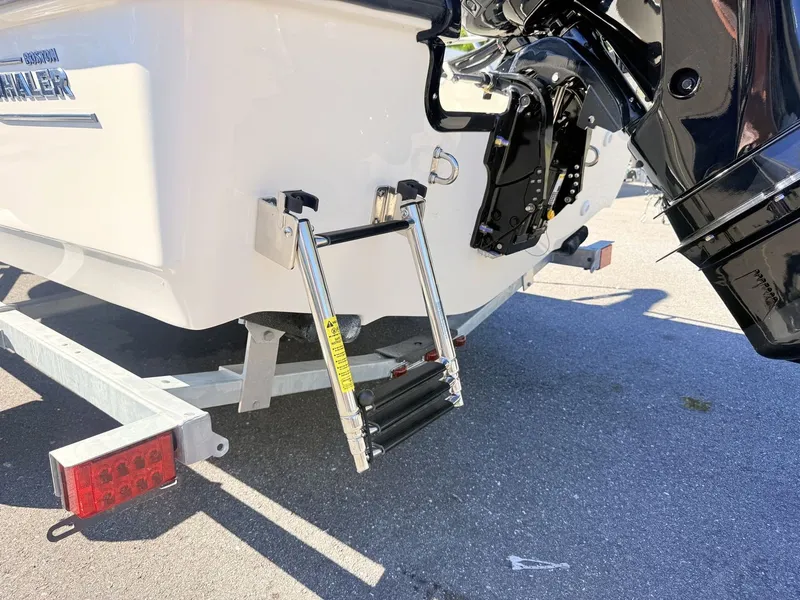 Slide: The Image of A 2027 Boston Whaler 150 Montauk with a retractable swim ladder at the stern. - 13