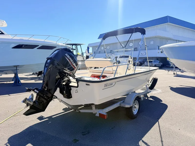 Slide: The Image of A 2027 Boston Whaler 150 Montauk on a trailer. It features an outboard motor. - 4