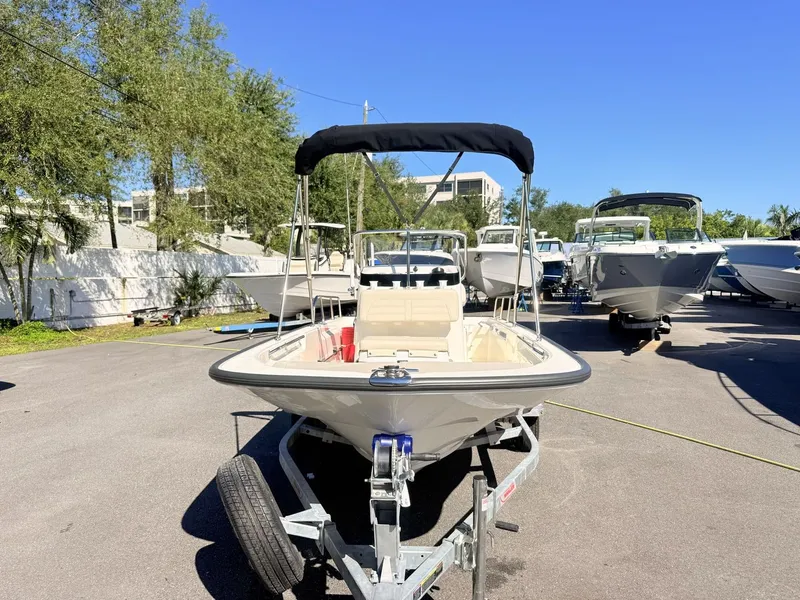 Slide: The Image of A 2027 Boston Whaler 150 Montauk sits on a trailer in a sunny marina. - 10