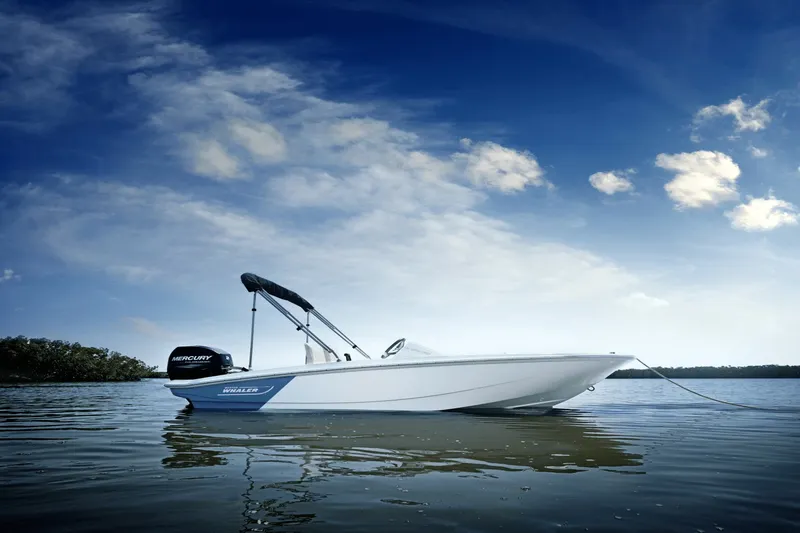 Slide: The Image of A 2027 Boston Whaler 130 Super Sport on calm water under a blue sky. - 5