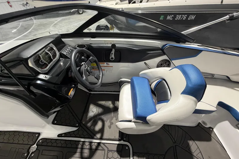 Slide: The Image of Interior of a 2022 Scarab 195 ID boat featuring a modern dashboard and blue-accented seating. - 10
