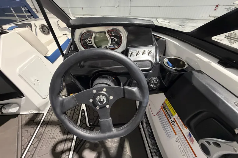 Slide: The Image of Cockpit view of 2022 Scarab 195 ID boat with steering wheel and dashboard controls. - 8