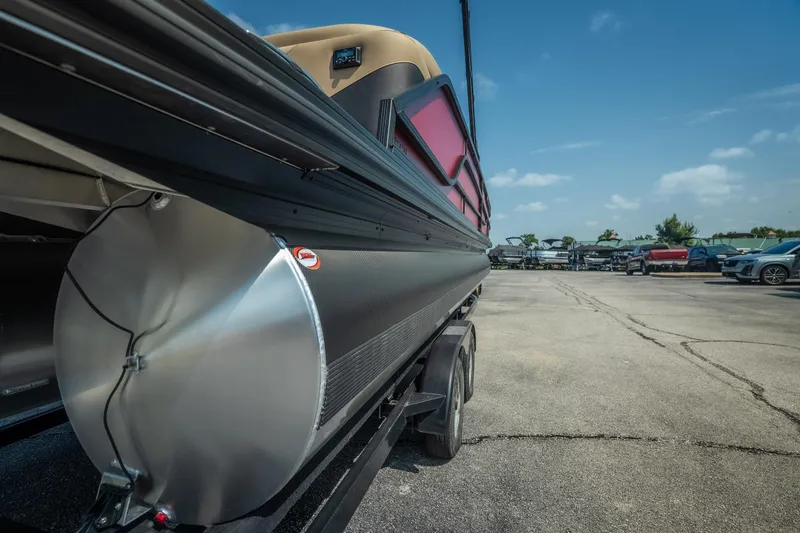 Slide: The Image of 2026 Evotti 525QL pontoon boat on trailer in parking lot, under clear blue sky. - 9