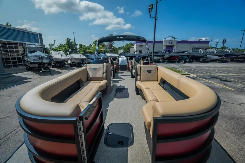 Slide: The Image of 2026 Evotti 525QL pontoon boat with luxurious seating, displayed at a dealership under a clear sky. - 12