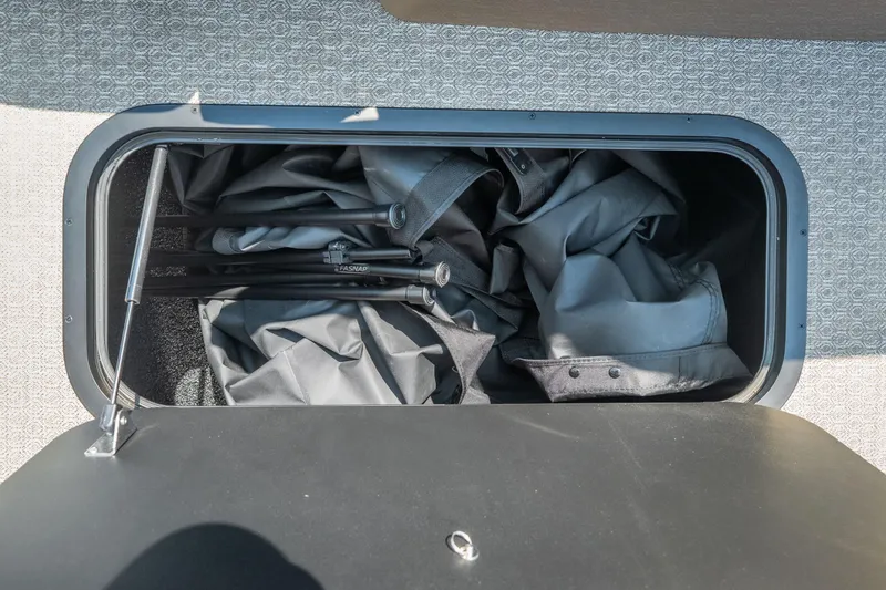Slide: The Image of Storage compartment in 2026 Evotti 525QL, containing folded fabric and metal poles. - 22