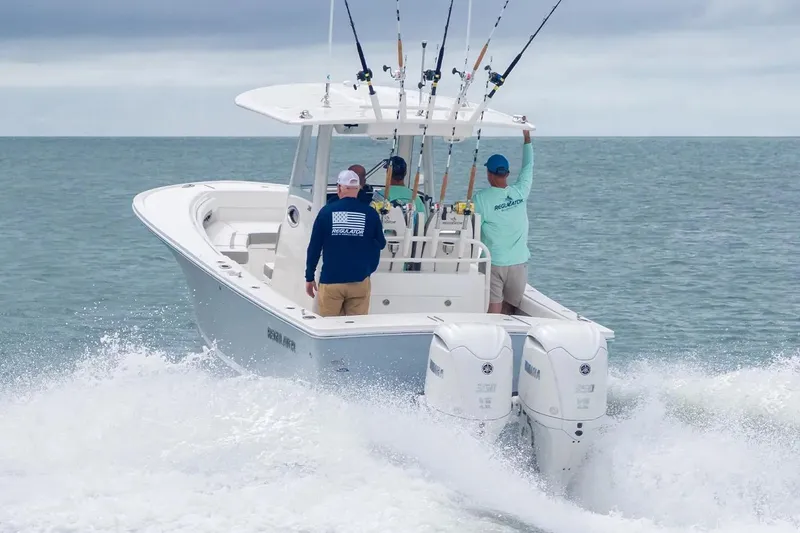 Slide: The Image of Manufacturer Provided Image: 2026 Regulator 28 boat navigating ocean waves with fishing rods and crew. - 3