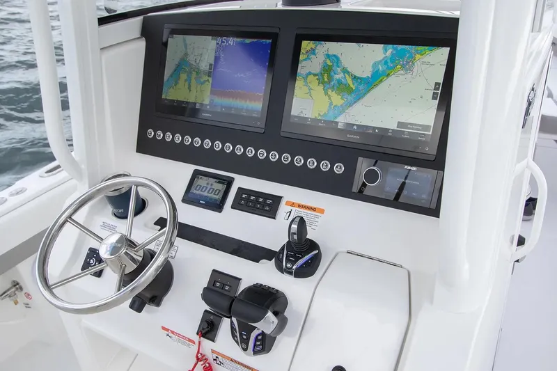 Slide: The Image of Manufacturer Provided Image: 2026 Regulator 28 boat dashboard with dual navigation screens and steering wheel. - 5