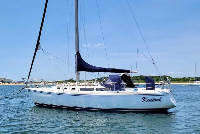 Slide: The Image of 1986 Catalina 34 sailboat named "Kestrel" anchored in calm waters under a clear blue sky. - 19