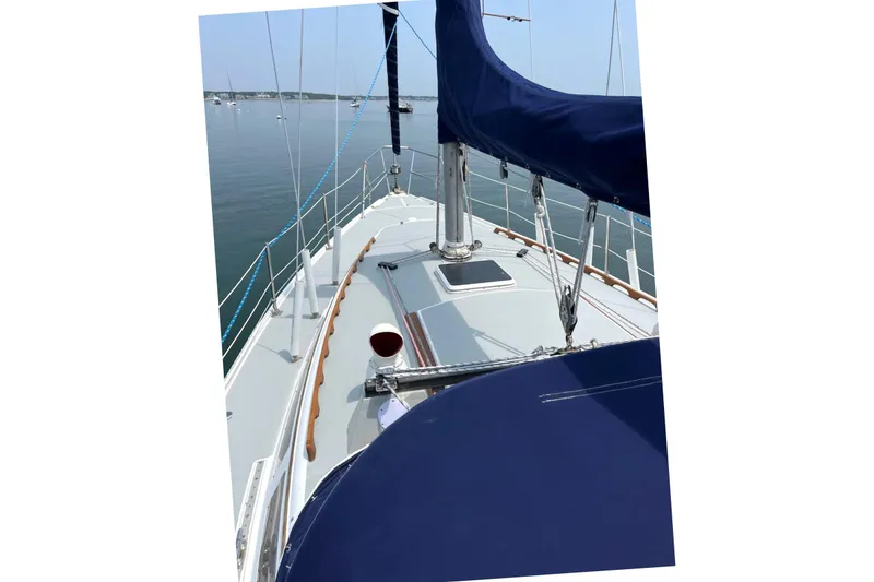 Slide: The Image of 1986 Catalina 34 MkII sailboat deck with blue sail cover, calm waters in background. - 20