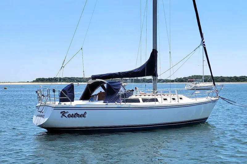 Slide: The Image of 1986 Catalina 34 sailboat named "Kestrel" anchored in calm waters. - 15