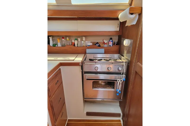 Slide: The Image of Compact kitchen area in a 1986 Catalina 34 sailboat with stove and storage. - 10