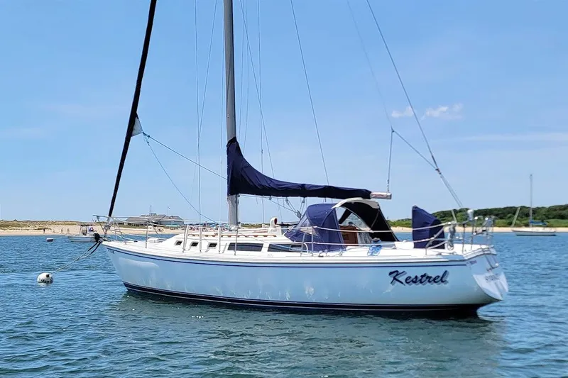 Slide: The Image of 1986 Catalina 34 sailboat named "Kestrel" anchored in calm waters under a clear blue sky. - 3