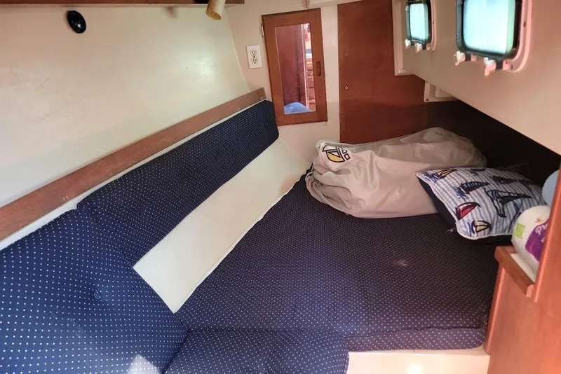 Slide: The Image of Cozy cabin interior of a 1986 Catalina 34 sailboat with blue cushions and nautical decor. - 9