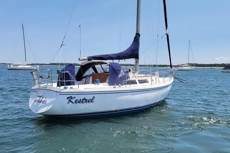 Slide: The Image of 1986 Catalina 34 sailboat named "Kestrel" anchored in a sunny harbor. - 22