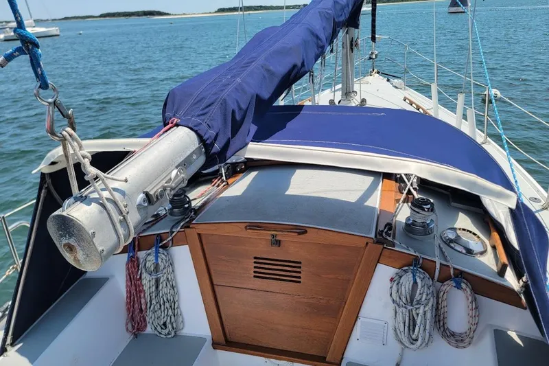 Slide: The Image of 1986 Catalina 34 sailboat cockpit with blue canvas cover and ropes, anchored on calm water. - 4