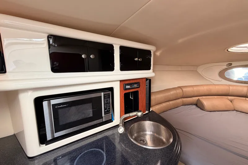 Slide: The Image of 2009 Monterey 250 Cruiser interior with kitchenette, microwave, sink, and seating area. - 17