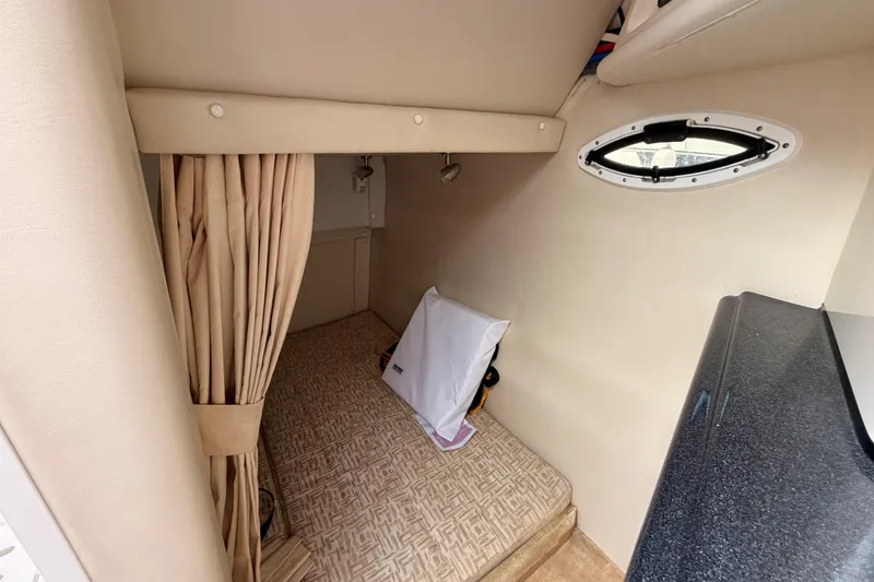 Slide: The Image of Interior cabin of a 2009 Monterey 250 Cruiser with beige decor and a small window. - 14