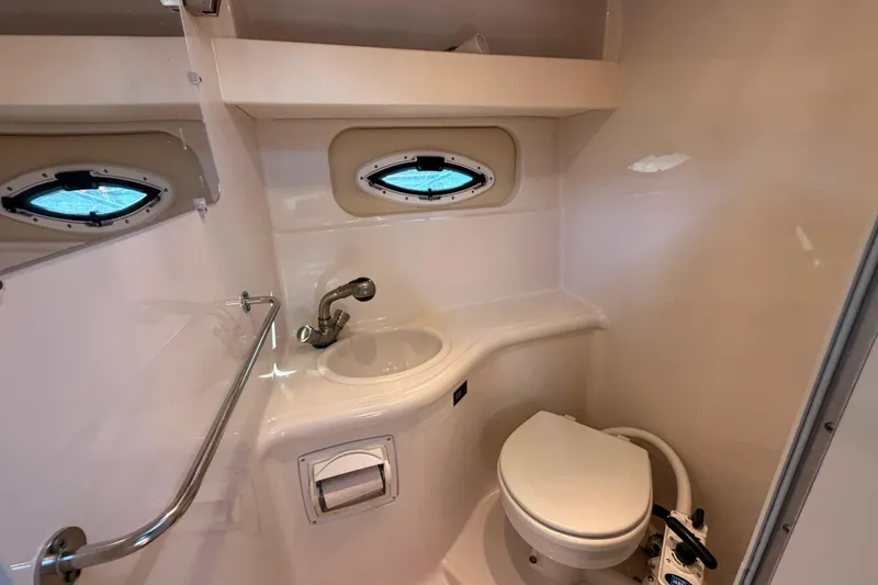 Slide: The Image of 2009 Monterey 250 Cruiser bathroom with sink, toilet, and porthole window. - 18