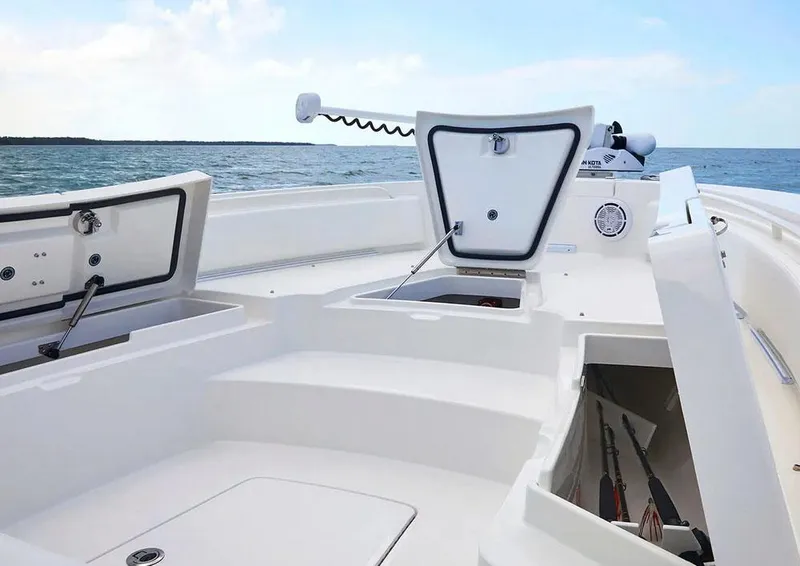 Slide: The Image of Manufacturer Provided Image: Regulator 26XO 2026 boat with open storage compartments on water. - 8