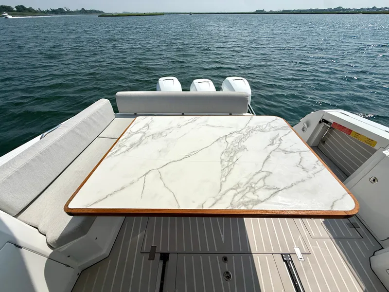 Slide: The Image of A luxurious marble-look table on a 2019 Azimut Verve 40, surrounded by water. - 5