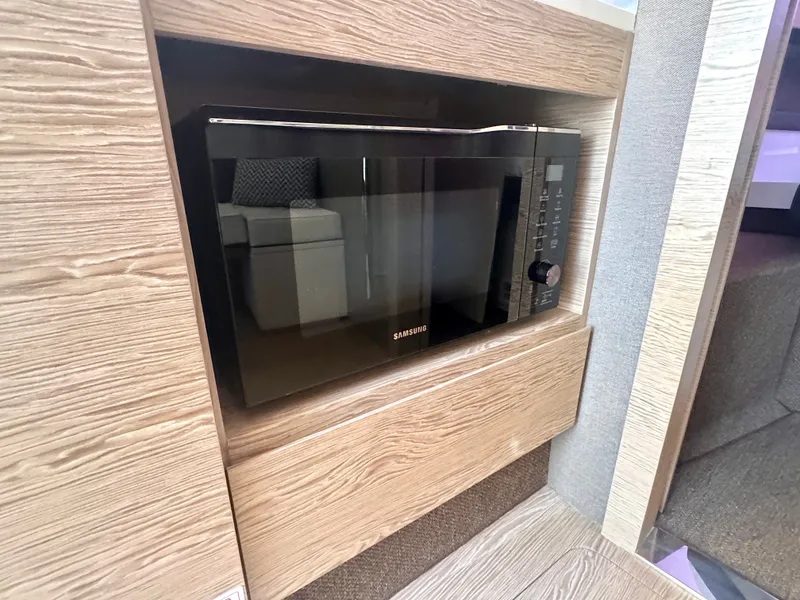 Slide: The Image of A microwave is built into a wooden panel, surrounded by modern interior materials. - 34