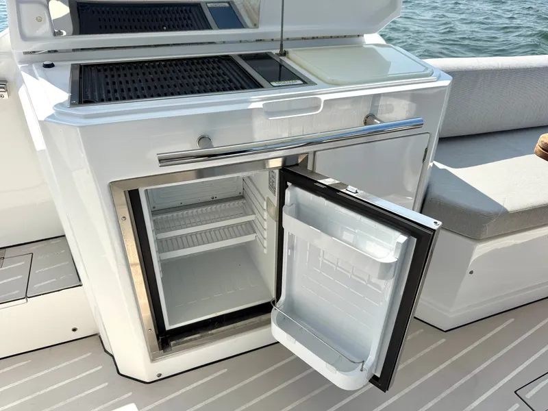 Slide: The Image of An open refrigerator on a 2019 Azimut Verve 40 boat, with gray seating cushions. - 10