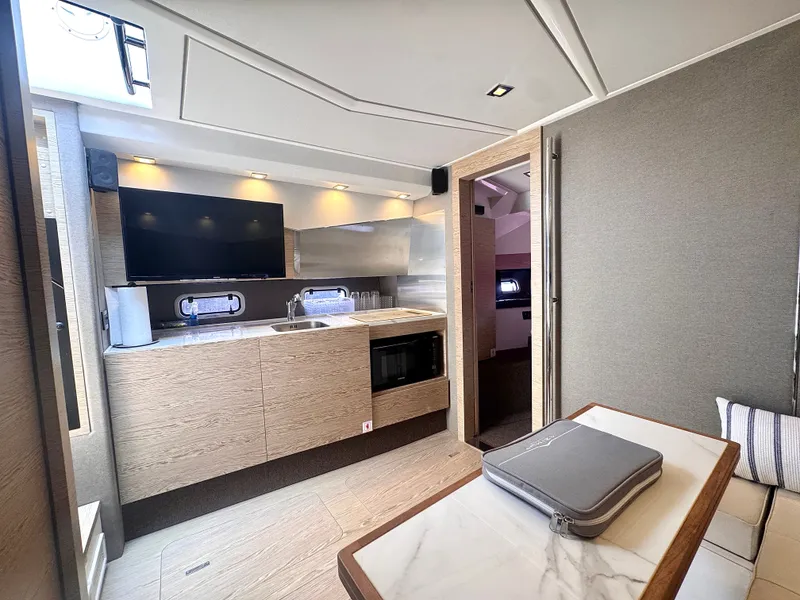 Slide: The Image of The interior of a 2019 Azimut Verve 40 features a modern kitchen with wood paneling and a TV. - 29