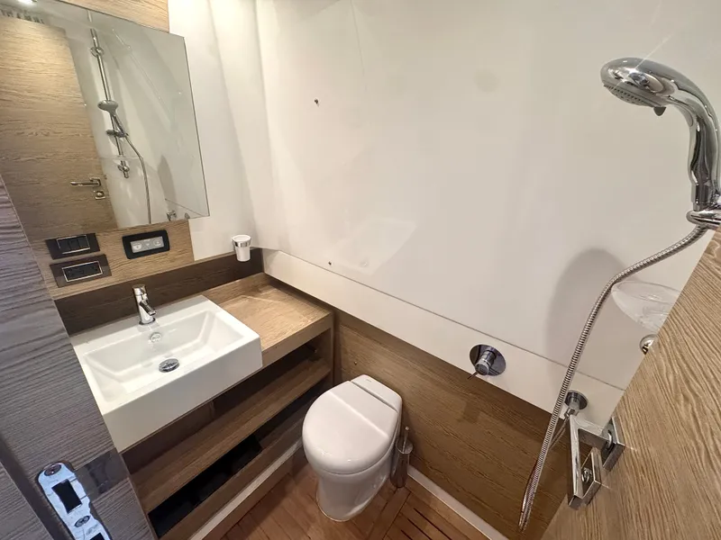 Slide: The Image of The image shows a modern yacht bathroom with a sink, toilet, and shower. - 35