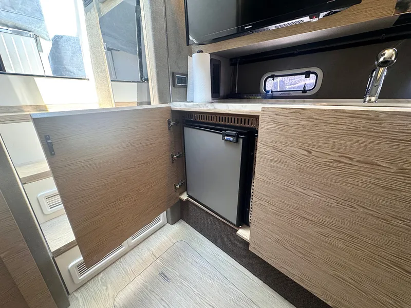 Slide: The Image of The interior of a 2019 Azimut Verve 40 shows an open cabinet door and a refrigerator. - 32