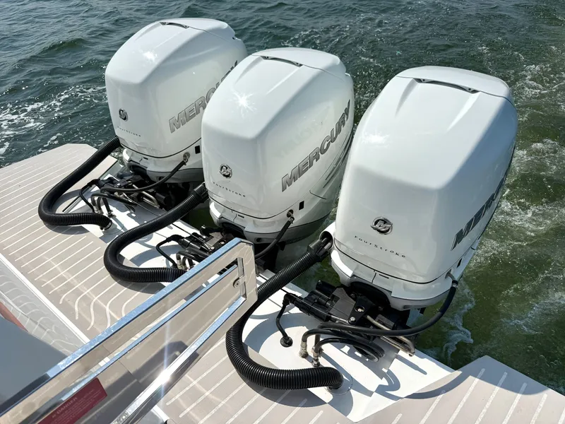 Slide: The Image of Three white Mercury outboard engines are mounted on the stern of a boat on the water. - 25