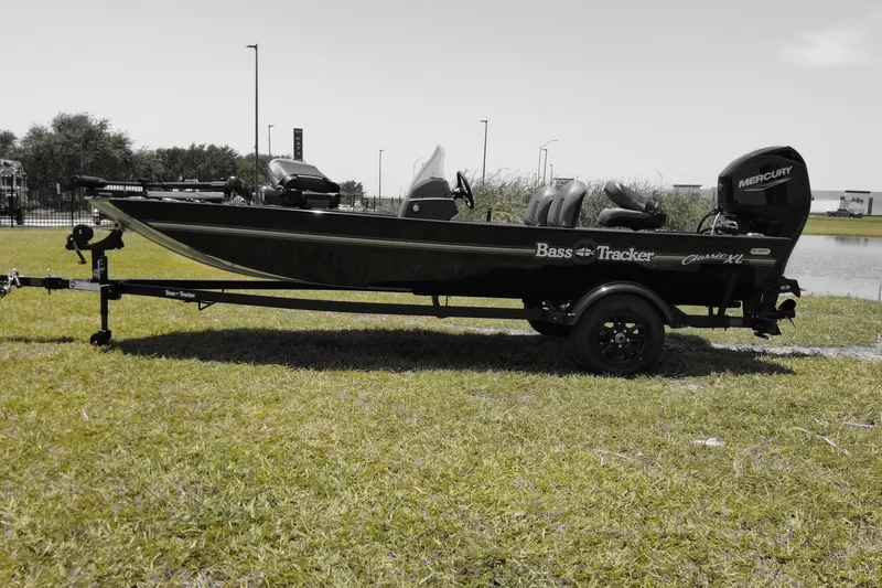Slide: The Image of 2026 Bass Tracker boat on trailer, parked on grass near water. - 7