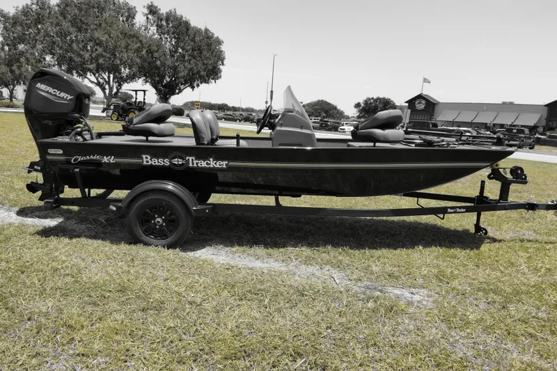 Slide: The Image of 2026 Bass Tracker Classic XL boat on trailer, parked on grass, with Mercury engine. - 6