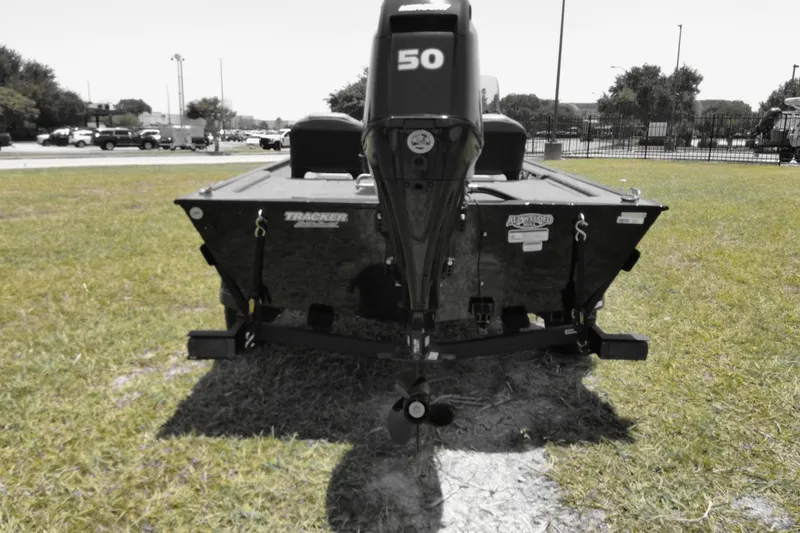 Slide: The Image of 2026 Bass Tracker boat with 50 HP motor, parked on grass. - 5