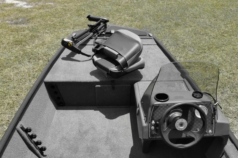 Slide: The Image of 2026 Bass Tracker boat interior with steering wheel and seating on grassy background. - 9