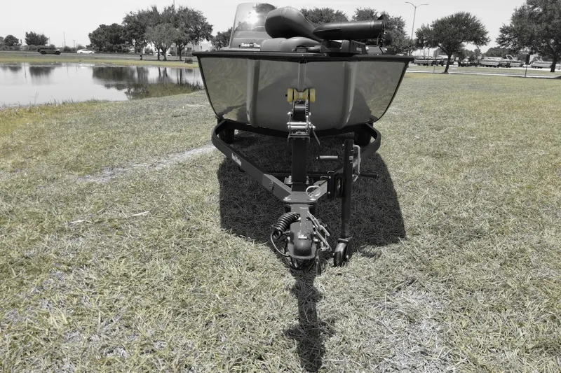 Slide: The Image of 2026 Bass Tracker boat on trailer near a serene lake, surrounded by lush greenery. - 2