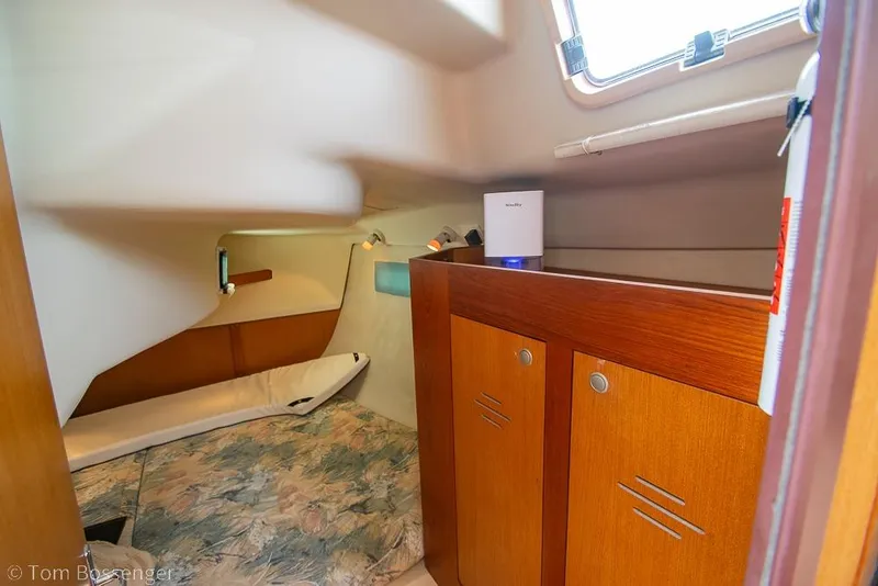 Slide: The Image of Interior cabin of a 1999 Hunter 340 sailboat with wooden cabinets and a cozy bed. - 18