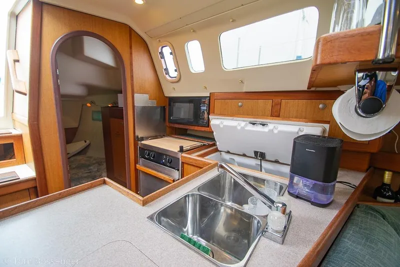 Slide: The Image of Interior of a 1999 Hunter 340 sailboat kitchen with sink, stove, and storage. - 10