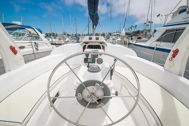 Slide: The Image of Cockpit view of a 1999 Hunter 340 sailboat in a marina, showcasing steering wheel and controls. - 25