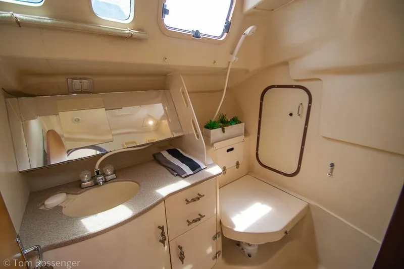 Slide: The Image of Interior of 1999 Hunter 340 yacht bathroom with sink, mirror, and showerhead. - 23