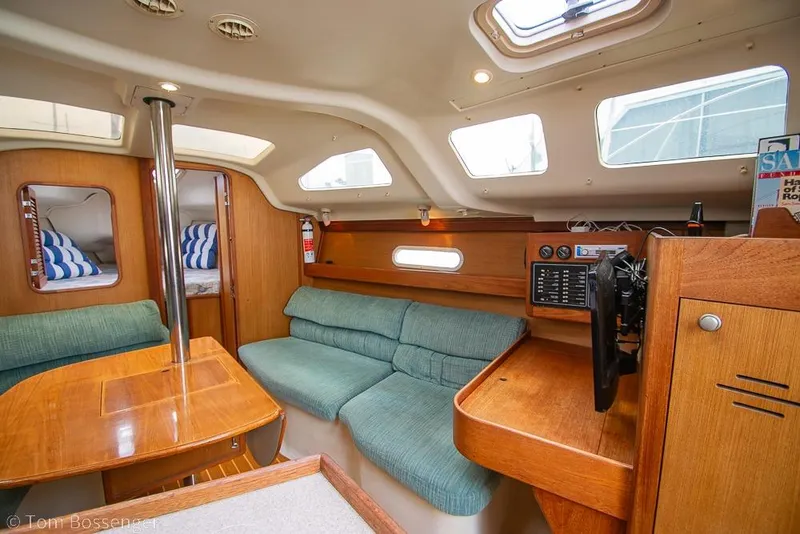 Slide: The Image of Interior of a 1999 Hunter 340 sailboat with cozy seating and wooden finishes. - 9