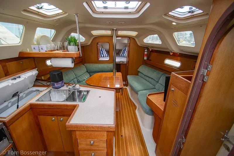 Slide: The Image of Interior of a 1999 Hunter 340 sailboat with wood finish and cozy seating area. - 7