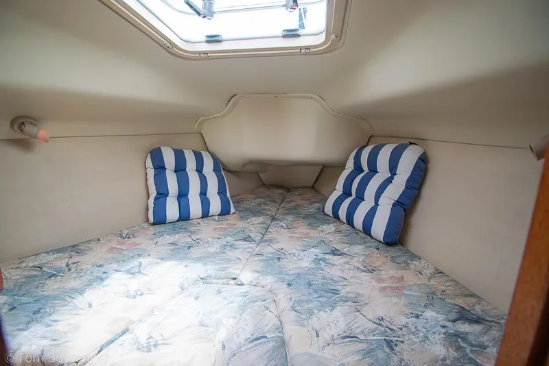 Slide: The Image of Cozy cabin interior of 1999 Hunter 340 sailboat with striped cushions and floral bedding. - 17