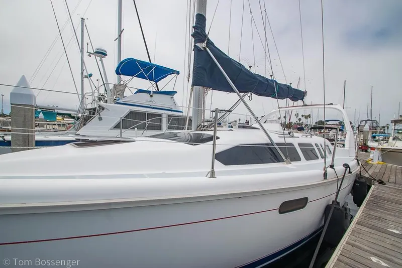 Slide: The Image of Hunter 340 sailboat from 1999 docked at a marina, showcasing sleek design and rigging. - 3