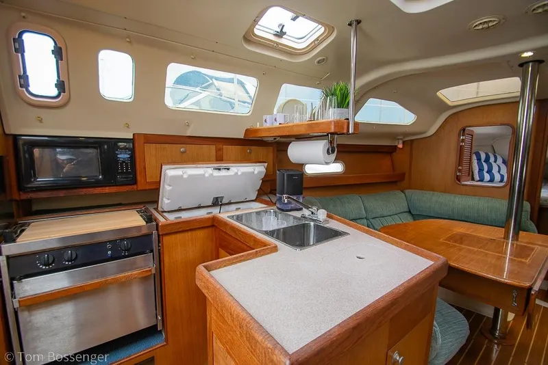 Slide: The Image of Interior of a 1999 Hunter 340 sailboat featuring a cozy kitchen and seating area. - 8