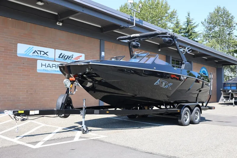 Slide: The Image of A black ATX Surf Boat 22 Type-S from 2027 is on a trailer in front of a building. - 15