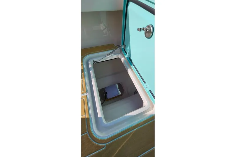 Slide: The Image of Open storage compartment on 2025 Insetta 35IFC boat, featuring a teal lid and secure latch. - 14