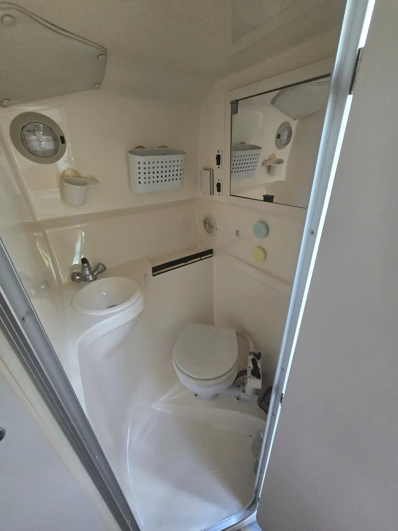 Slide: The Image of The image shows a compact boat bathroom with a toilet, sink, and mirror. - 13