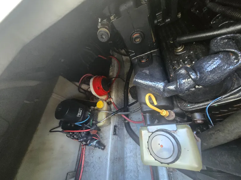 Slide: The Image of The engine compartment of a 1998 Doral 250 SC showing various mechanical components and wiring. - 17