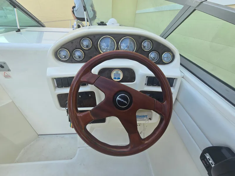 Slide: The Image of The image shows the cockpit of a 1998 Doral 250 SC with a wooden steering wheel and instruments. - 8